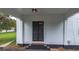 Side entry with a storm door, painted white wood, and decorative columns at 6104 Floyd St, Covington, GA 30014