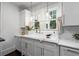 Charming kitchen sink beneath double windows, featuring white cabinets, granite counters and stylish fixtures at 6104 Floyd St, Covington, GA 30014