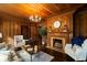 Inviting living room with wood paneling, fireplace, hardwood floors, and comfortable seating, perfect for relaxing and entertaining at 6104 Floyd St, Covington, GA 30014