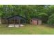 View of backyard outbuildings: a wooden shed and an open air covered structure at 6104 Floyd St, Covington, GA 30014