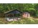 Outdoor space featuring a covered area with a brick fireplace and a small brick building at 6104 Floyd St, Covington, GA 30014