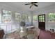 Sun-filled sun room with brick floor, panelled walls, classic ceiling fan, and furniture at 6104 Floyd St, Covington, GA 30014