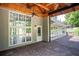 Covered back porch with two ceiling fans, stamped concrete floor and a view of the backyard at 704 Willowwind Dr, Loganville, GA 30052
