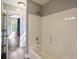 Bright bathroom featuring a shower-tub combo with white tile surround and modern fixtures at 704 Willowwind Dr, Loganville, GA 30052