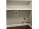 Convenient laundry area with a washer-dryer hookup and built-in shelving for storage at 704 Willowwind Dr, Loganville, GA 30052