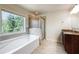 Bright bathroom with a soaking tub, glass-enclosed shower, and a granite-topped vanity at 337 Liberty Dr, Acworth, GA 30102