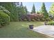 A lush backyard featuring a well-manicured lawn and beautiful landscaping with evergreen trees at 12955 Mariners Ct, Alpharetta, GA 30005