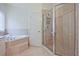 Bright bathroom with a glass-enclosed shower and soaking tub at 12955 Mariners Ct, Alpharetta, GA 30005