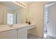 Bright bathroom featuring a large mirror, white cabinets, and modern fixtures at 12955 Mariners Ct, Alpharetta, GA 30005