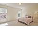 Light-filled bedroom featuring neutral tones, two windows, and a side table at 12955 Mariners Ct, Alpharetta, GA 30005