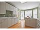 Bright kitchen with hardwood floors, white cabinets, and a breakfast nook offers ample space and natural light at 12955 Mariners Ct, Alpharetta, GA 30005
