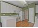 Bright kitchen with hardwood floors, white cabinets, and modern appliances offers ample space for cooking and storage at 12955 Mariners Ct, Alpharetta, GA 30005