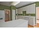 Bright kitchen with hardwood floors, white cabinets, modern appliances, and access to the staircase at 12955 Mariners Ct, Alpharetta, GA 30005