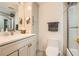 This bathroom showcases a large mirror over a vanity, cabinet for linens, and a toilet at 199 14Th St # 2502, Atlanta, GA 30309