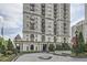 Exterior view of a high-rise building with manicured landscaping and circular driveway at 199 14Th St # 2502, Atlanta, GA 30309