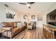 Comfortable living room featuring a brown leather sofa, ceiling fan, and hardwood floors at 199 14Th St # 2502, Atlanta, GA 30309