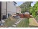 Backyard featuring a deck with steps, stone patio, and landscaped features at 4630 Carriage Walk Ln, Cumming, GA 30040