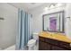 Bathroom featuring a shower with blue curtain, toilet, and wood vanity with stylish glass vessel sink at 4630 Carriage Walk Ln, Cumming, GA 30040