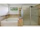 Beautiful bathroom featuring a bathtub and glass-enclosed shower with decorative tile surround at 4630 Carriage Walk Ln, Cumming, GA 30040