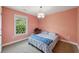 Cozy bedroom with carpet, window view, light fixture, and salmon-colored walls at 4630 Carriage Walk Ln, Cumming, GA 30040
