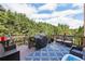 Inviting deck with outdoor seating, grill, blue rug, and wooded backdrop at 4630 Carriage Walk Ln, Cumming, GA 30040