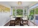 Sunny dining area with a modern chandelier, hardwood floors, and large windows overlooking the backyard at 4630 Carriage Walk Ln, Cumming, GA 30040