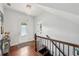 Bright foyer with hardwood floors, staircase, and decorative light fixture at 4630 Carriage Walk Ln, Cumming, GA 30040
