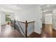 Hallway with hardwood floors, decorative railing, and natural light from large window at 4630 Carriage Walk Ln, Cumming, GA 30040