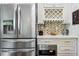 Close-up of a modern kitchen with stainless steel refrigerator, microwave, and wine rack at 4630 Carriage Walk Ln, Cumming, GA 30040