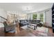 Open concept living room featuring a large sectional, hardwood floors, and natural light at 4630 Carriage Walk Ln, Cumming, GA 30040