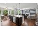 Bright, open concept featuring kitchen, dining area, and living room with fireplace and built-in bookshelves at 4630 Carriage Walk Ln, Cumming, GA 30040