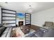Cozy living room with a fireplace, built-in bookshelves, modern chandelier, and comfortable leather couches at 4630 Carriage Walk Ln, Cumming, GA 30040