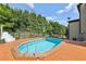 Backyard in-ground pool, surrounded by wooden deck and lush greenery at 4630 Carriage Walk Ln, Cumming, GA 30040