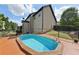 In-ground pool with wooden deck, surrounded by trees and home exterior at 4630 Carriage Walk Ln, Cumming, GA 30040