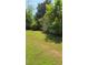 A tranquil backyard with lush greenery and a chair tucked beside the home's exterior at 65 King James Se Ct, Conyers, GA 30013