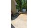 Side view of the home with a concrete patio, a partial fence, and various yard equipment at 65 King James Se Ct, Conyers, GA 30013