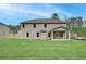 Spacious backyard featuring a two-story house with a covered patio, set against a blue sky at 100 Bree Dr, Fayetteville, GA 30214
