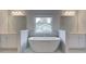 Bright bathroom featuring a large soaking tub under a window, with separate vanities on either side at 100 Bree Dr, Fayetteville, GA 30214