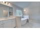 Airy bathroom with a soaking tub, dual vanities, and ample natural light from a large window at 100 Bree Dr, Fayetteville, GA 30214