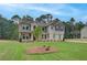 New construction home with manicured lawn and a mix of stone and siding with a side-entry garage at 100 Bree Dr, Fayetteville, GA 30214