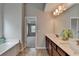 Elegant bathroom featuring a double vanity with a large mirror, a garden tub, and access to the bedroom at 1345 Aster Ives Dr, Lawrenceville, GA 30045
