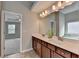 Bathroom featuring a large vanity with double sinks, a framed mirror, and access to the Primary bedroom at 1345 Aster Ives Dr, Lawrenceville, GA 30045