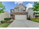 Charming two-story home featuring a brick facade, large two car garage, and a well manicured front lawn at 1345 Aster Ives Dr, Lawrenceville, GA 30045