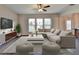 Cozy living room featuring a ceiling fan, large windows, and plush seating with a contemporary rug at 1345 Aster Ives Dr, Lawrenceville, GA 30045
