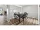 Bright dining room featuring wood floors, a black metal table, and matching chairs at 213 Yuba Walk, Lawrenceville, GA 30046