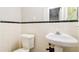 Bathroom with a pedestal sink, toilet, tile walls and a mirror at 3697 Wisteria Sw Ln, Atlanta, GA 30331