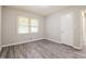Bedroom featuring neutral walls, gray laminate flooring, window, and a door at 3697 Wisteria Sw Ln, Atlanta, GA 30331