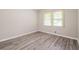 Bright bedroom with a window and gray wood-look flooring at 3697 Wisteria Sw Ln, Atlanta, GA 30331