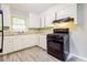 Functional kitchen boasts a black gas range, neutral counters, and white cabinets at 3697 Wisteria Sw Ln, Atlanta, GA 30331