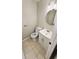 Neutral half-bathroom featuring tiled flooring, a sleek round mirror, and a modern floating vanity at 381 Fleming Ct, Jonesboro, GA 30238
